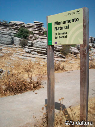 Cartel y al fondo el Monumento Natural El Tornillo del Torcal - Rutas de Senderismo por el Torcal de Antequera