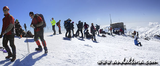 Montañeros y Esquiadores de Travesía junto al vértice geodésico Veleta - Rutas de Senderismo en invierno en la Estación de Esquí Sierra Nevada