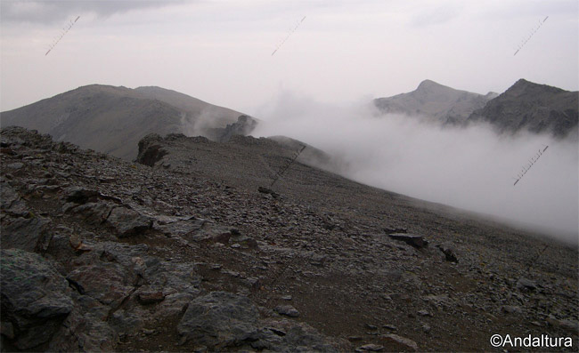 Nubes sobre la Loma de Cuerda Alta en el Valle de Lanjarón, al fondo el Pico del Tajo de los Machos y el la otra vertiente el Cerro del Caballo y Tajos Altos