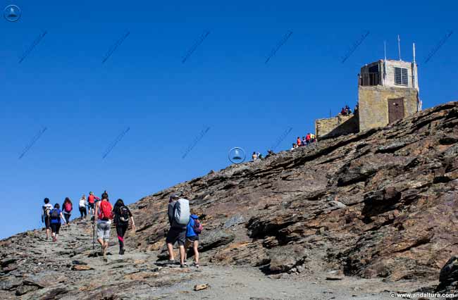Montañeros llegando al Vértice Geodésico Veleta - Rutas de Senderismo por los Tresmiles de Sierra Nevada
