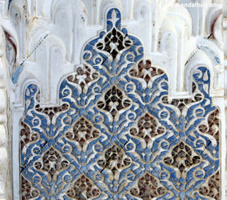 Detalle de yesería de colores azules y rojos en el Palacio de los Leones de la Alhambra