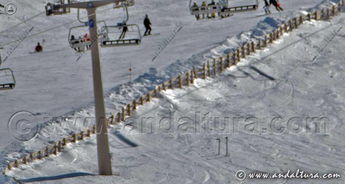 Paravientos y cañones de nieve artificial junto a los postes del Telesilla Stadium en la Estación de Esquí Sierra Nevada