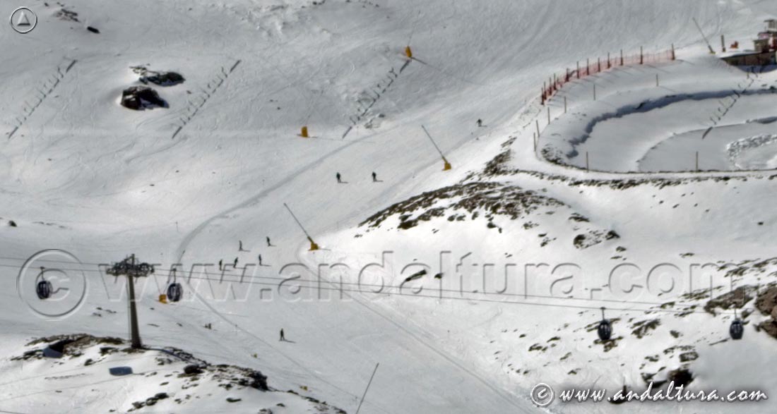 Descendiendo por la pista Zahareña junto a una de las balsas artificiales para los cañones de nieves de la Estación de Esquí Sierra Nevada